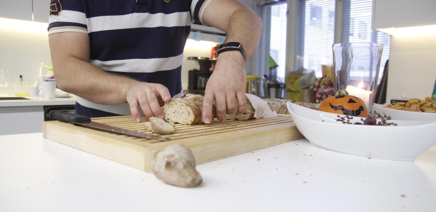 Javi leikkaamassa leipää siivuiksi toimistolla